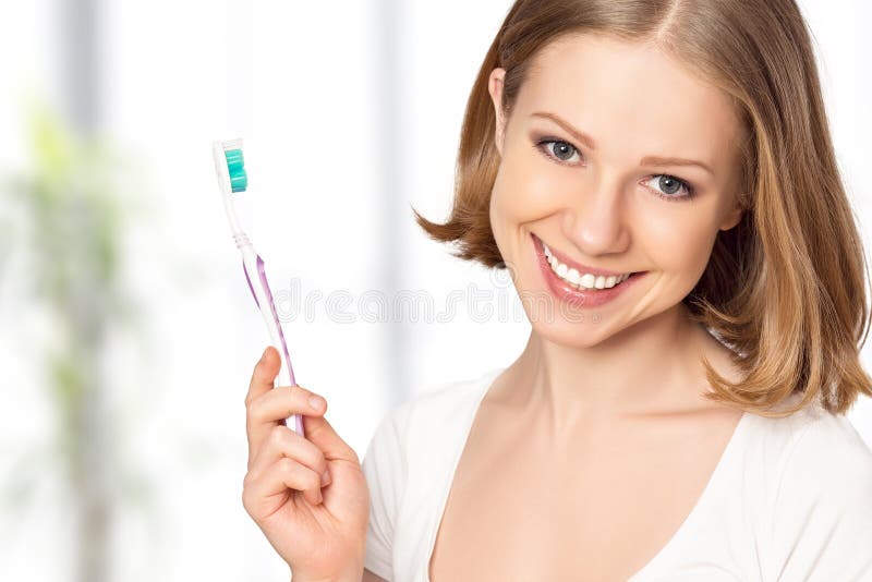 Healthy happy young woman with snow-white smile brushing her teeth with a toothbrush. Healthy happy young woman with snow-white smile brushing her teeth with a toothbrush