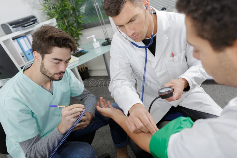 医生与病人及实习医生一起学习 免版税库存图片