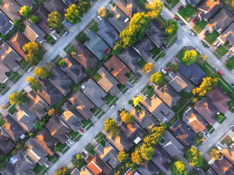 Aerial view residential houses and intersecting driveways neighborhood subdivision fall sunset. Tightly packed homes surrounds mature trees flyover in Houston, Texas, US. Suburban housing development. Aerial view residential houses and intersecting driveways neighborhood subdivision fall sunset. Tightly packed homes surrounds mature trees flyover in Houston, Texas, US. Suburban housing development