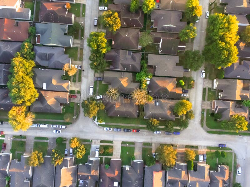 Aerial view residential houses and intersecting driveways neighborhood subdivision fall sunset. Tightly packed homes surrounds mature trees flyover in Houston, Texas, US. Suburban housing development. Aerial view residential houses and intersecting driveways neighborhood subdivision fall sunset. Tightly packed homes surrounds mature trees flyover in Houston, Texas, US. Suburban housing development