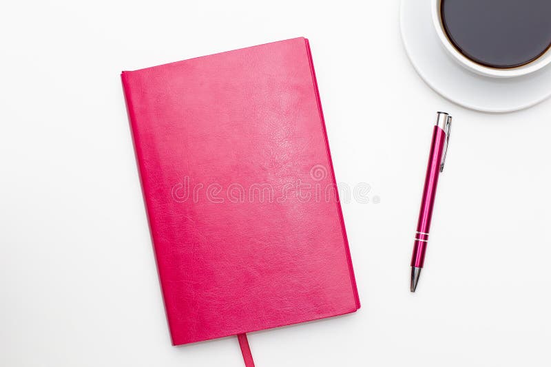Pink notebook with pen and a Cup of black coffee on white. business minimal concept for women. Flat lay, top view. Pink notebook with pen and a Cup of black coffee on white. business minimal concept for women. Flat lay, top view.
