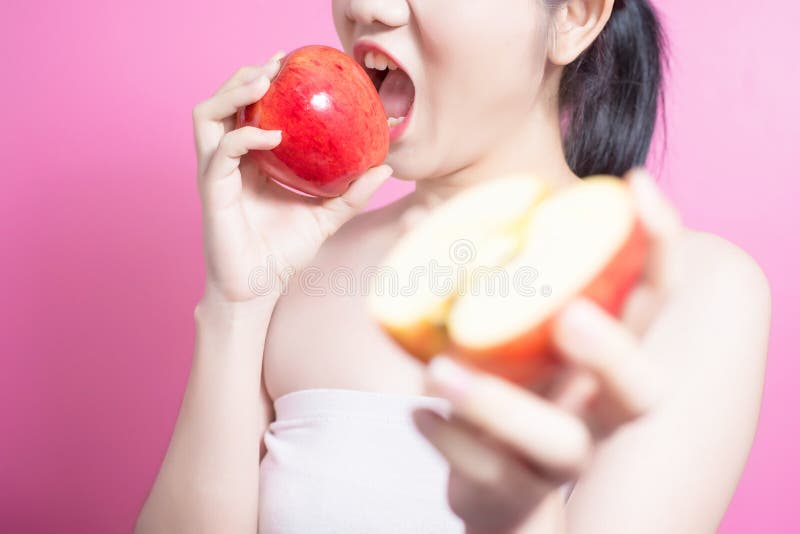 有苹果概念的亚裔妇女 微笑和拿着苹果的她 秀丽面孔和自然构成 隔绝在桃红色背景 免版税库存照片 有苹果概念的亚裔妇女 微笑和拿着苹果的她 秀丽面孔和自然构成 隔绝在桃红色背景 免版税库存照片