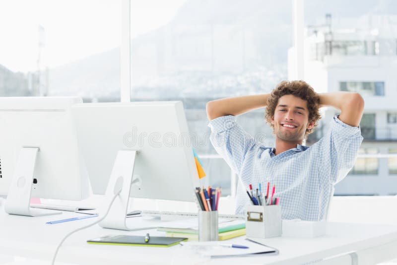 有计算机的轻松的偶然商人在明亮的办公室 库存图片