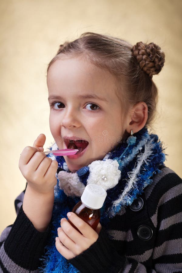 Little girl with warm clothes taking cough medicine syrup. Little girl with warm clothes taking cough medicine syrup