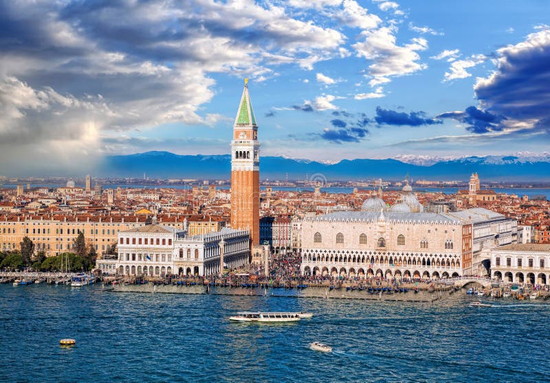 Piazza San Marco with Bell Tower and the Doge Palace against Italian Alps in Venice Italy. Piazza San Marco with Bell Tower and the Doge Palace against Italian Alps in Venice Italy