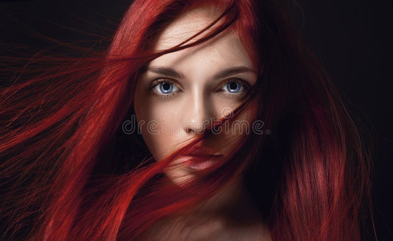 有长的头发的性感的美丽的红头发人女孩 在黑背景的完善的妇女画象 华美的头发和深大蓝眼睛