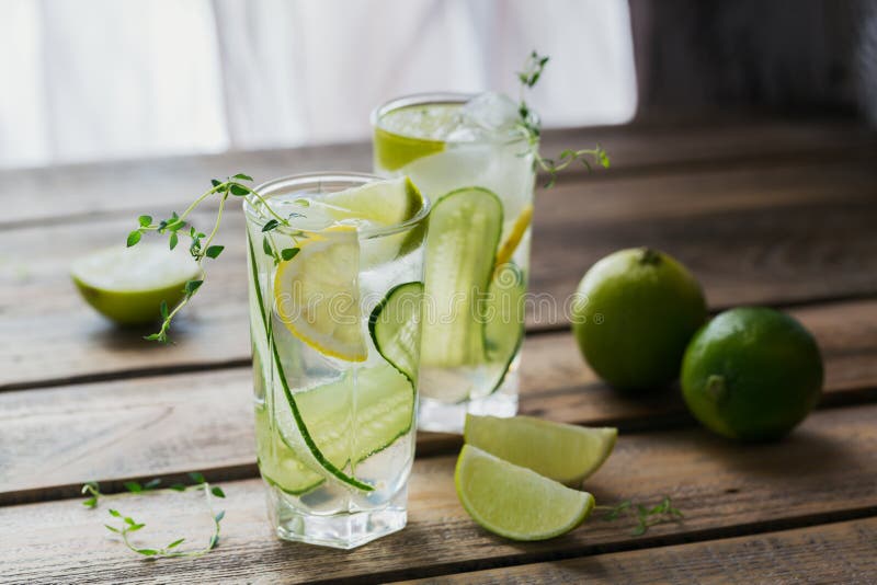 Glass of cucumber soda drink on wooden table. Summer healthy detox infused water, lemonade or cocktail background. Low alcohol, nonalcoholic drinks, super food, vegetarian or healthy diet concept. Glass of cucumber soda drink on wooden table. Summer healthy detox infused water, lemonade or cocktail background. Low alcohol, nonalcoholic drinks, super food, vegetarian or healthy diet concept