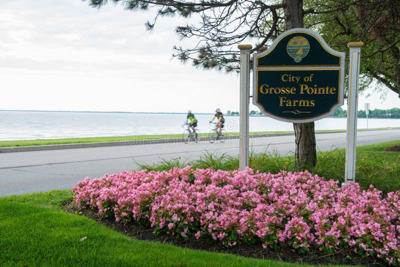 The City of Grosse Pointe Farms, Michigan along Jefferson Avenue with Lake Saint Clair in the background as two bicyclist ride by. The City of Grosse Pointe Farms, Michigan along Jefferson Avenue with Lake Saint Clair in the background as two bicyclist ride by.