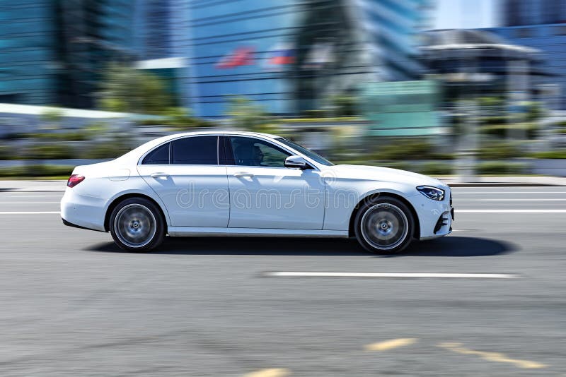 Moscow, Russia - June 2022: Mercedes E Class W213 riding on city road. Side view of white car on asphalt road in motion. Overspeed in city concept. Moscow, Russia - June 2022: Mercedes E Class W213 riding on city road. Side view of white car on asphalt road in motion. Overspeed in city concept