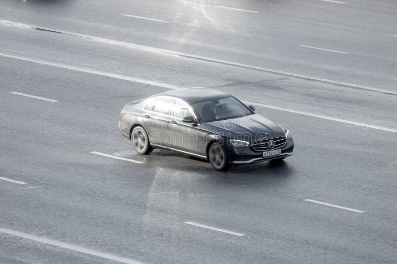 Moscow, Russia - February 2023: Aerial front side view of Mercedes Benz E Class W213 Facelift car moving on city road. Driver in black sedan E-Class rushes for job on highway. Moscow, Russia - February 2023: Aerial front side view of Mercedes Benz E Class W213 Facelift car moving on city road. Driver in black sedan E-Class rushes for job on highway