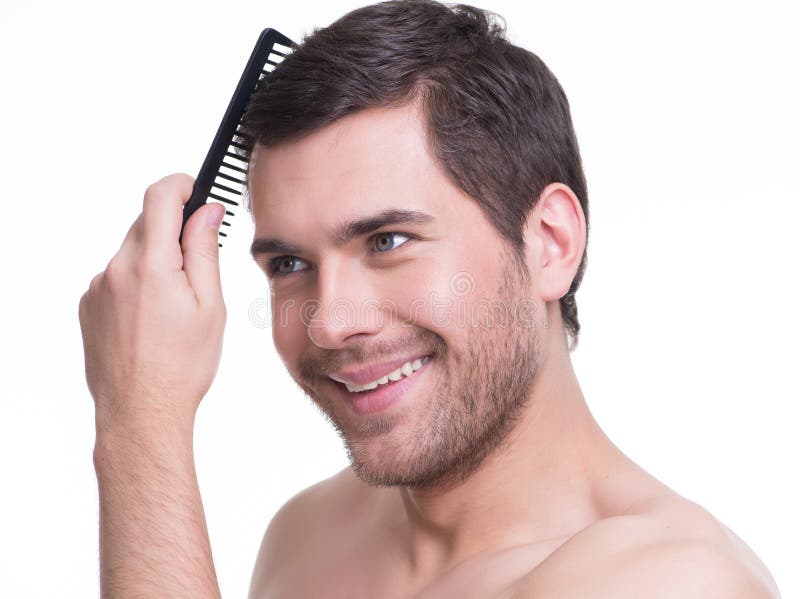 Portrait of a happy young man combing hair on a white background. Portrait of a happy young man combing hair on a white background.