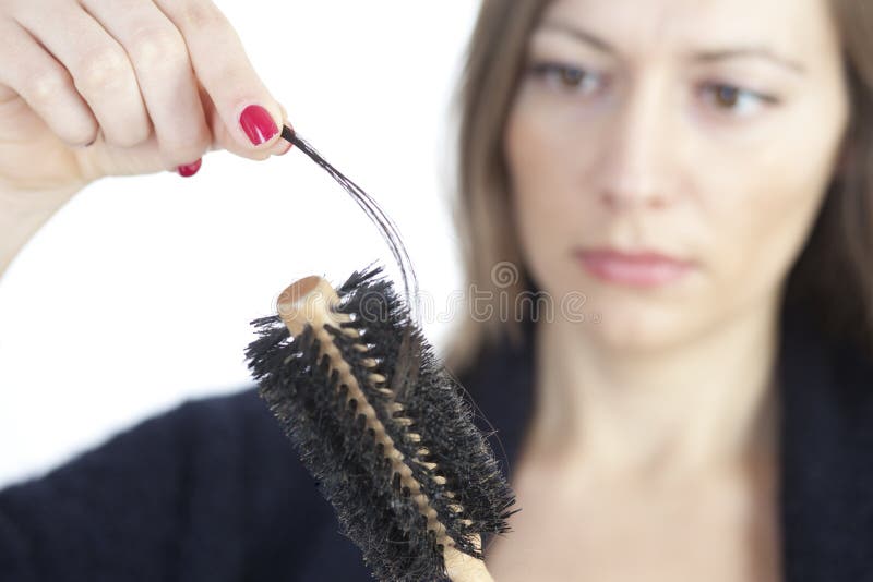 Woman checking her hairbrush for lost hair. Woman checking her hairbrush for lost hair