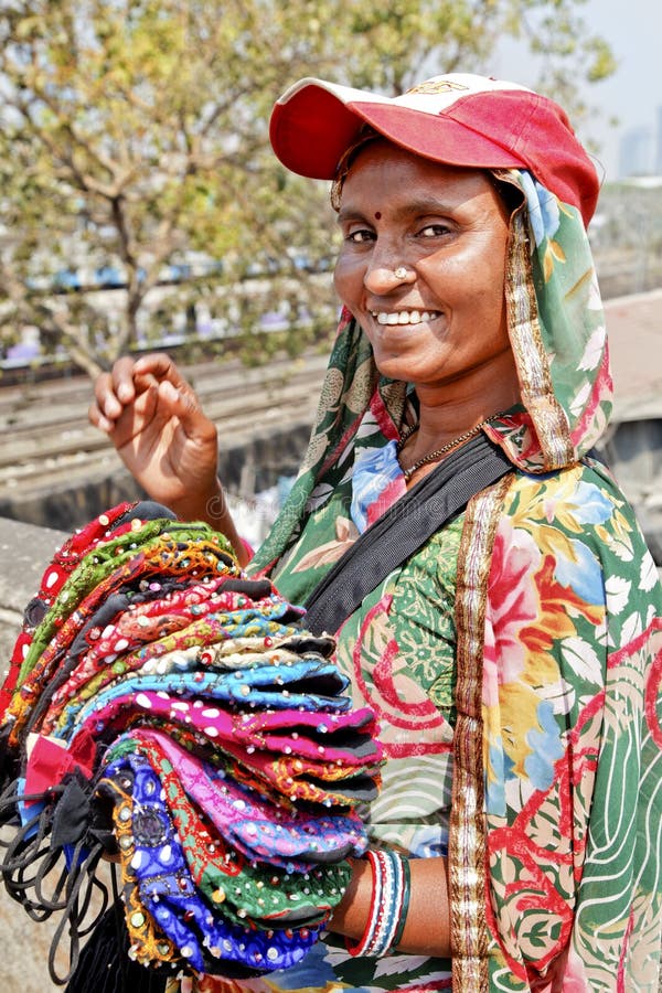 Mumbai, India at the tourist spot, Dhobhi Ghat, portrait of smiling colorful smiling purse street vendor with baseball hat. Mumbai, India at the tourist spot, Dhobhi Ghat, portrait of smiling colorful smiling purse street vendor with baseball hat