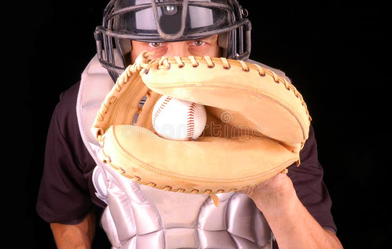 Baseball catcher in gear with caught pitch in mitt. Baseball catcher in gear with caught pitch in mitt