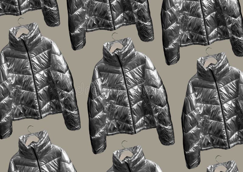 Metallic puffer down jacket on a hanger isolated on brown background. Composition of clothes. Flat lay, top view, copy space. Winter clothes pattern.  Padded coat Pattern. Metallic puffer down jacket on a hanger isolated on brown background. Composition of clothes. Flat lay, top view, copy space. Winter clothes pattern.  Padded coat Pattern