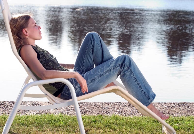 Blonde woman relaxing on a deckchair. Blonde woman relaxing on a deckchair.