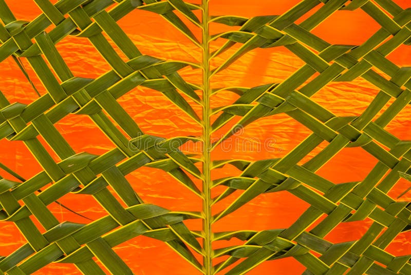 Coconut leaf weaving on the orange fabric . Coconut leaf weaving on the orange fabric .