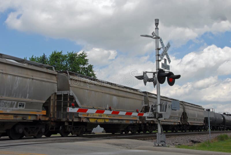 Freight train passing behind crossing gate. Freight train passing behind crossing gate