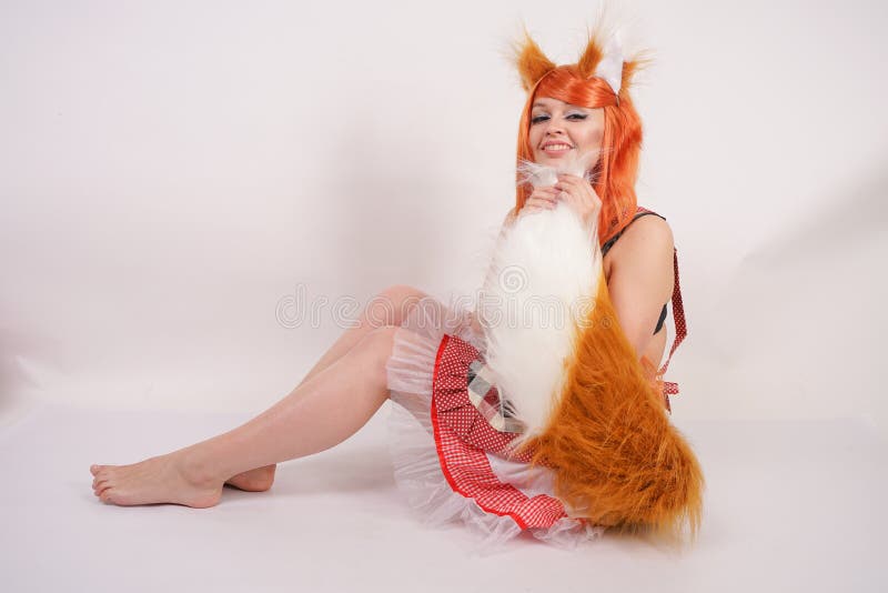橙色长的假发的迷人的Fox女孩与毛皮大佩带红色厨房格子花呢披肩围裙的耳朵和一条长的蓬松尾巴单独摆在光秃 库存照片 橙色长的假发的迷人的Fox女孩与毛皮大佩带红色厨房格子花呢披肩围裙的耳朵和一条长的蓬松尾巴单独摆在光秃 库存照片