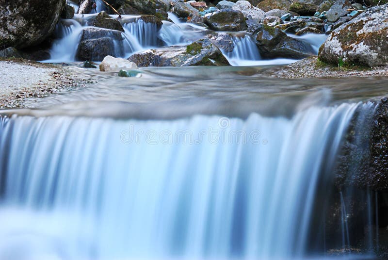 Water power from a small waterfall crossing a trail, Dolomites, Italy. Water power from a small waterfall crossing a trail, Dolomites, Italy