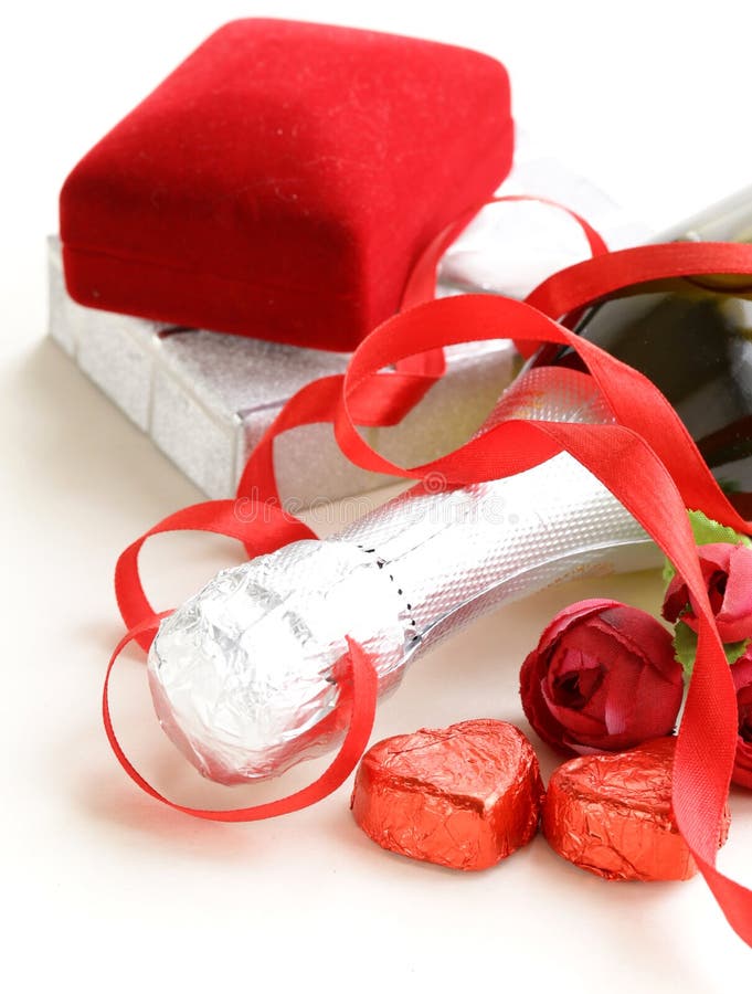 节日香槟酒瓶，配有巧克力和礼物 免版税库存照片