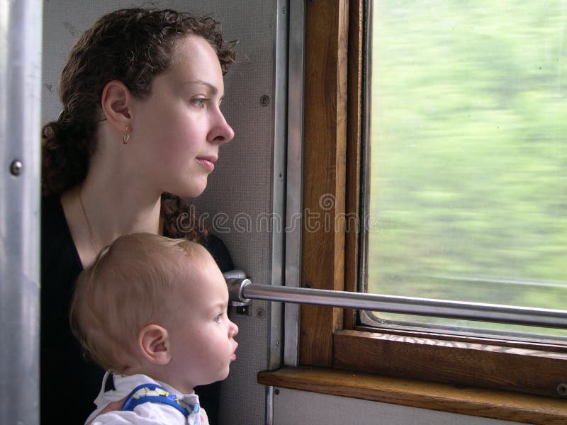 Wayfarers peer into window of train mother with son. Wayfarers peer into window of train mother with son