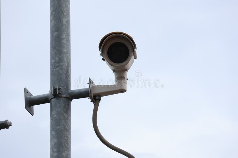 每天24小时运行的闭路电视摄像头被安装在建筑物外和户外公共区域的杆子上. 免版税库存照片