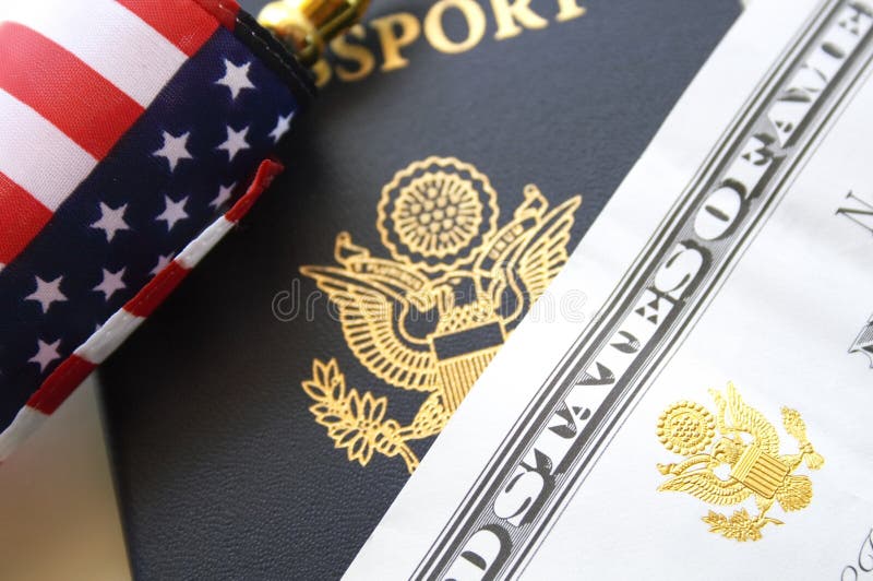 Immigration concept, US passport and flag over a citizenship and naturalization certificate. Immigration concept, US passport and flag over a citizenship and naturalization certificate