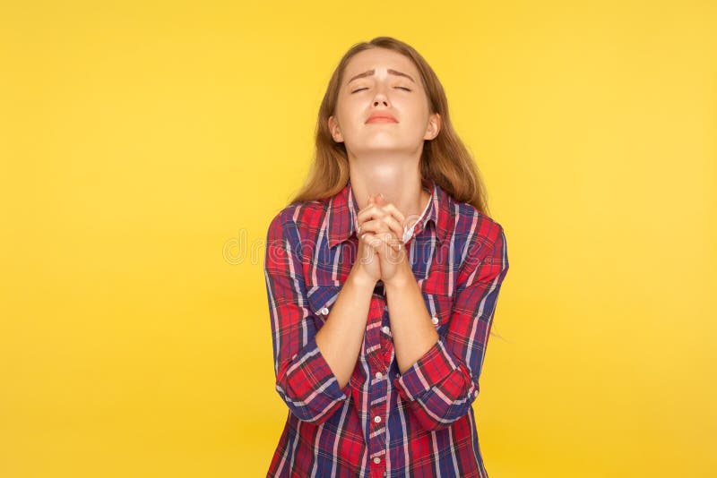 Please I`m begging! Portrait of despaired ginger girl in shirt keeping arms in prayer gesture and holding up head, appealing to god with imploring expression. studio shot isolated on yellow background. Please I`m begging! Portrait of despaired ginger girl in shirt keeping arms in prayer gesture and holding up head, appealing to god with imploring expression. studio shot isolated on yellow background