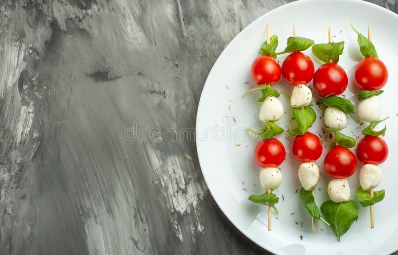 沙拉Caprese -烤肉串用蕃茄、无盐干酪和蓬蒿、意大利烹调和一健康素食在黑暗的背景 库存照片 沙拉Caprese -烤肉串用蕃茄、无盐干酪和蓬蒿、意大利烹调和一健康素食在黑暗的背景 库存照片