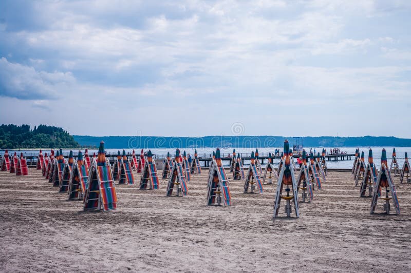 Closed parasols umbrellas on the beach, no people tourists. Closed parasols umbrellas on the beach, no people tourists.