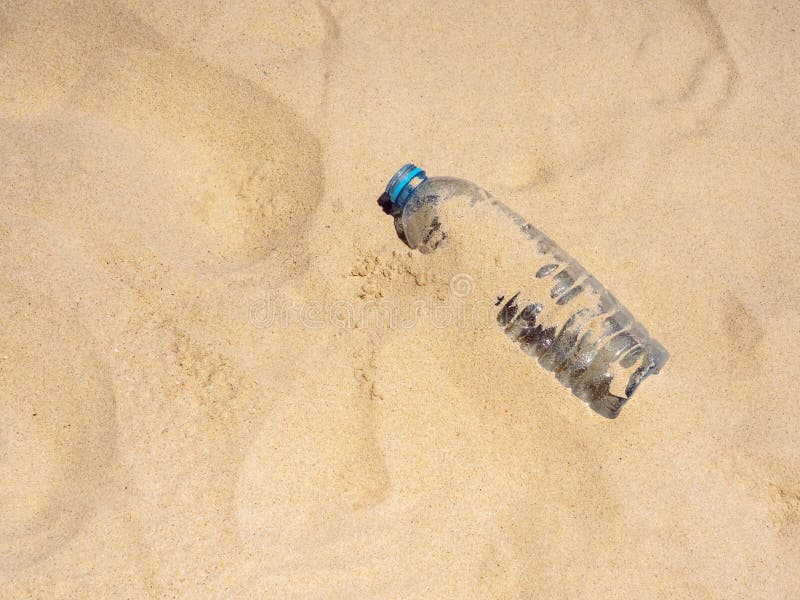 Plastic bottle on sandy beach, top view. Empty uncapped used plastic drinking water bottles piled up with sand, dumped on the beach with copy space. Polluted garbage abandoned by tourists. Plastic bottle on sandy beach, top view. Empty uncapped used plastic drinking water bottles piled up with sand, dumped on the beach with copy space. Polluted garbage abandoned by tourists.