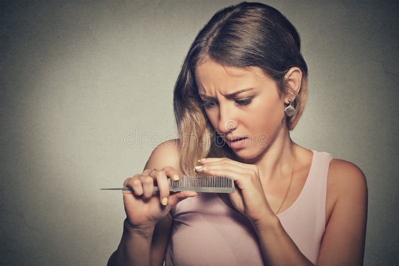 沮丧的少妇使她惊奇是丢失的头发，被注意的头发分叉 库存照片