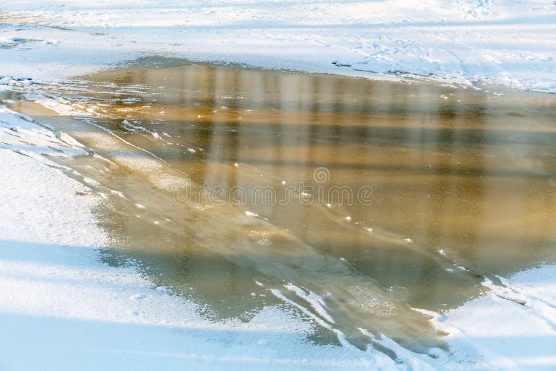 Inflowing water on the surface of river ice with footprints. Inflowing water on the surface of river ice with footprints