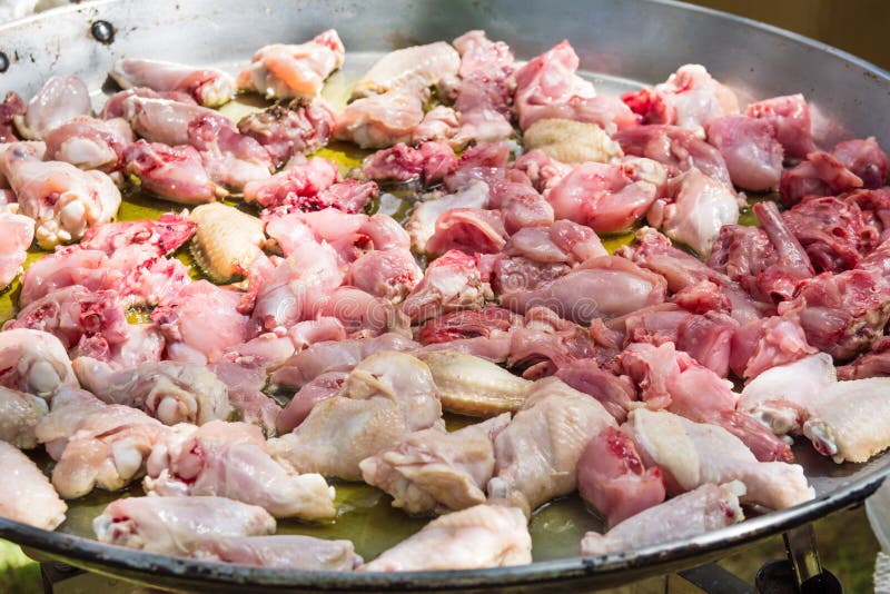 油煎在橄榄油的兔子和鸡水多的肉切片的过程在大平的肉菜饭长柄浅锅 燃烧器与开火 免版税图库摄影 油煎在橄榄油的兔子和鸡水多的肉切片的过程在大平的肉菜饭长柄浅锅 燃烧器与开火 免版税图库摄影