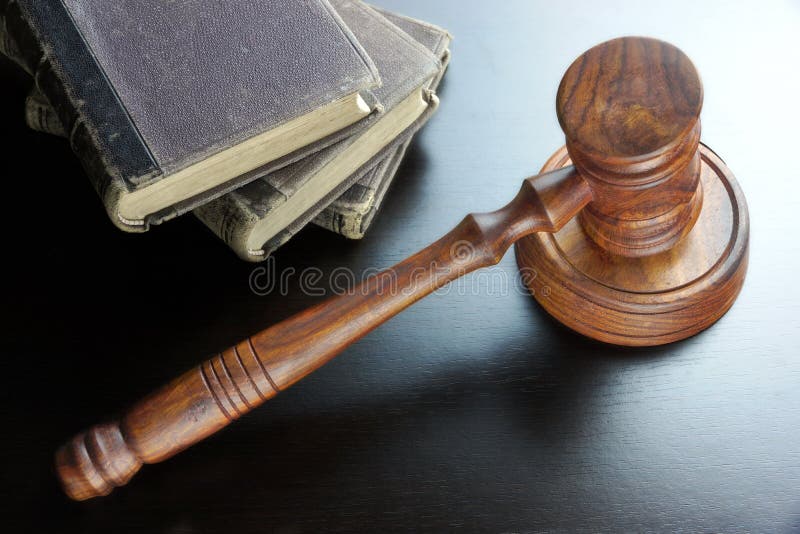 法官惊堂木和旧书在黑木表上 免版税图库摄影