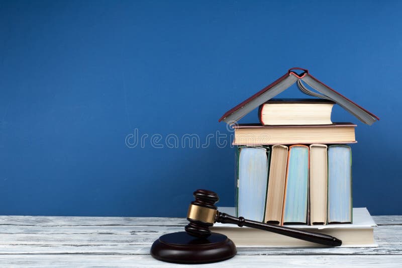 法律概念开放书，木质法官坐在法庭或执法办公室蓝色背景的桌子上. 复制空间 库存图片