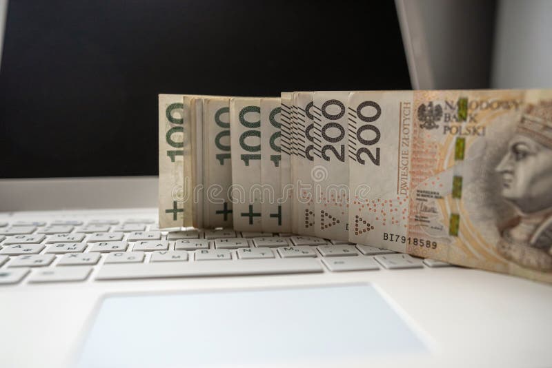100 200 Polish PLN cash on laptop computer, make money or buy online. Financial concept. 100 200 Polish PLN cash on laptop computer, make money or buy online. Financial concept