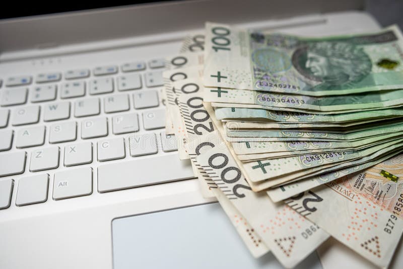 100 200 Polish PLN cash on laptop computer, make money or buy online. Financial concept. 100 200 Polish PLN cash on laptop computer, make money or buy online. Financial concept