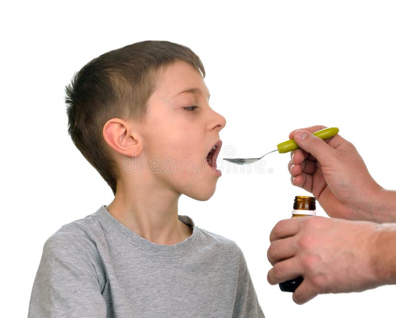 Father giving his son syrup because of the flu. Father giving his son syrup because of the flu