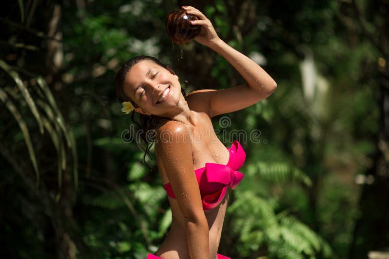 浇灌的性感的亭亭玉立的深色的年轻女性用新鲜的椰奶在狂放的绿色密林背景 皇家热带手段 免版税库存图片 浇灌的性感的亭亭玉立的深色的年轻女性用新鲜的椰奶在狂放的绿色密林背景 皇家热带手段 免版税库存图片