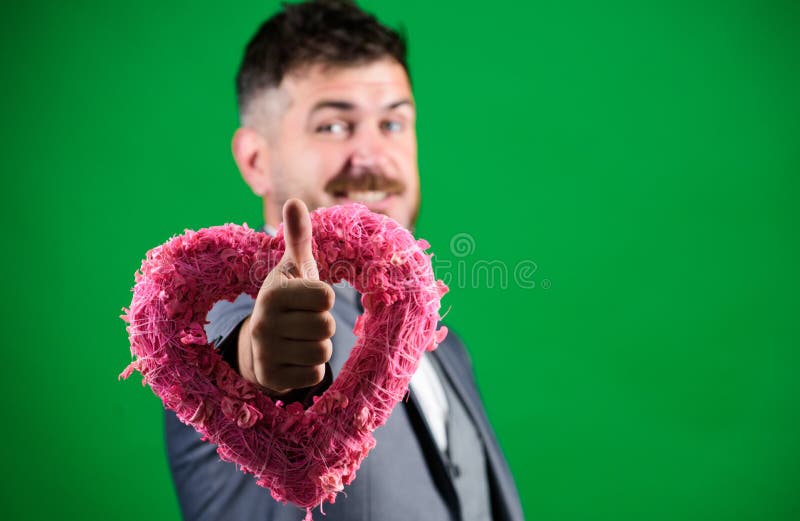 Romantic macho flirting. Happy valentines day. Hipster hold heart symbol love. Man formal suit celebrate valentines day green background. Spread love around. Happy in love. Hey pretty. Romantic macho flirting. Happy valentines day. Hipster hold heart symbol love. Man formal suit celebrate valentines day green background. Spread love around. Happy in love. Hey pretty.