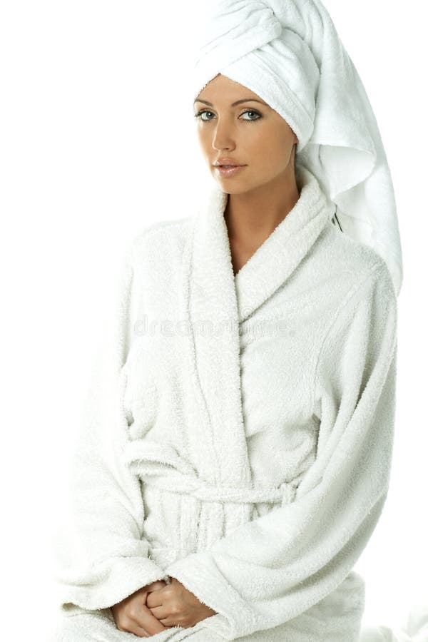 Half body portrait of young woman with white dressing gown or bath robe and towel around head, studio background. Half body portrait of young woman with white dressing gown or bath robe and towel around head, studio background.