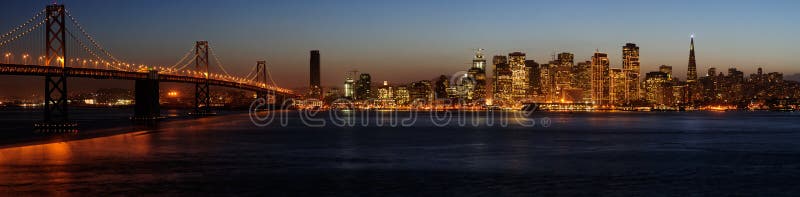 A high-resolution stitched image of Bay Bridge and San Francisco downtown decorated by Christmas lighting at dusk (shot from Treasure Island). This illumination is on for from late November to early January. Copyspace on top and bottom. A high-resolution stitched image of Bay Bridge and San Francisco downtown decorated by Christmas lighting at dusk (shot from Treasure Island). This illumination is on for from late November to early January. Copyspace on top and bottom.