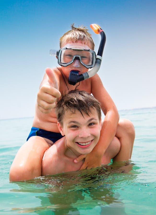 Two boys in the sea on a beach. Two boys in the sea on a beach