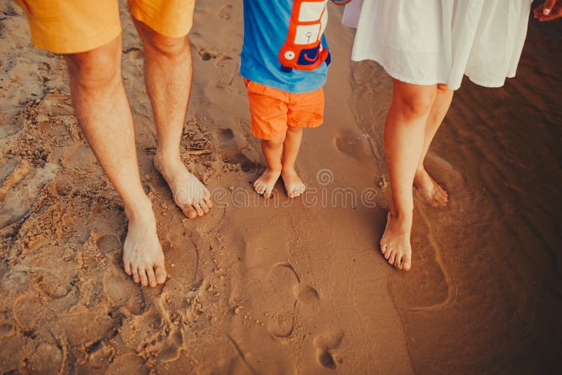海滩的幸福家庭 家庭脚特写镜头与走在沙子的男孩婴孩的 抱着他们的婴孩的男人和妇女 由的步行 库存照片 海滩的幸福家庭 家庭脚特写镜头与走在沙子的男孩婴孩的 抱着他们的婴孩的男人和妇女 由的步行 库存照片