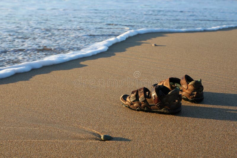 Sandals on a beach, photographed in early morning sunlight. Sandals on a beach, photographed in early morning sunlight