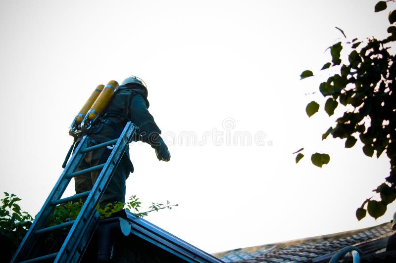 Fire acident. Firemen on the roof of a burning house. Fire acident. Firemen on the roof of a burning house