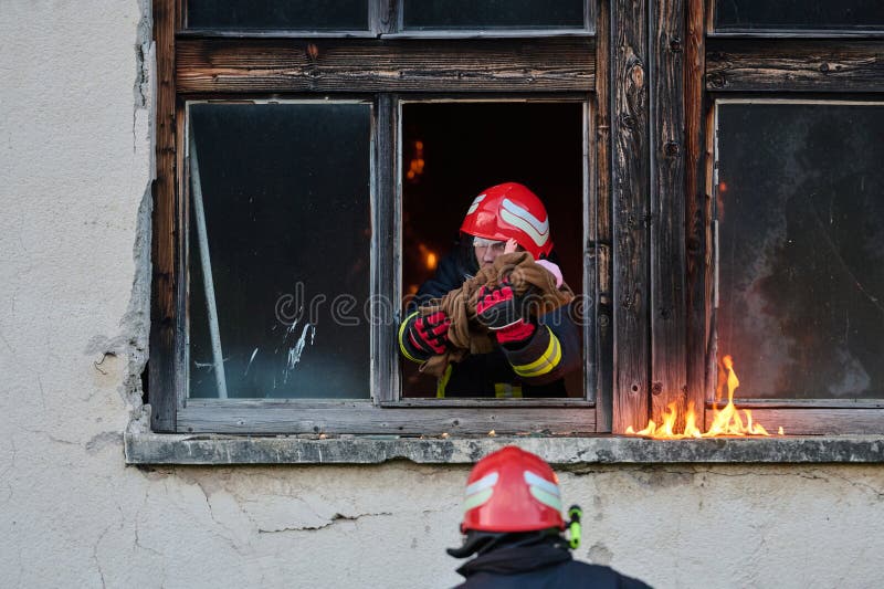 消防员从燃烧的建筑物中救出婴儿，勇敢的消防员行动，消防安全和紧急响应，戏剧性 库存照片