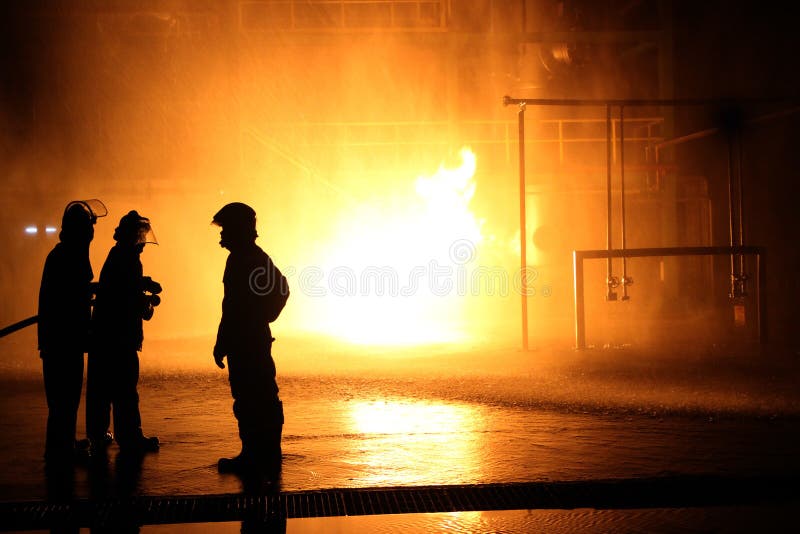 Firefighters and rescue training. Firefighter spraying high pressure water to fire Burning fire flame background. Firefighters and rescue training. Firefighter spraying high pressure water to fire Burning fire flame background